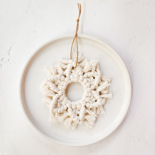 A white macrame snowflake ornaments on a white background