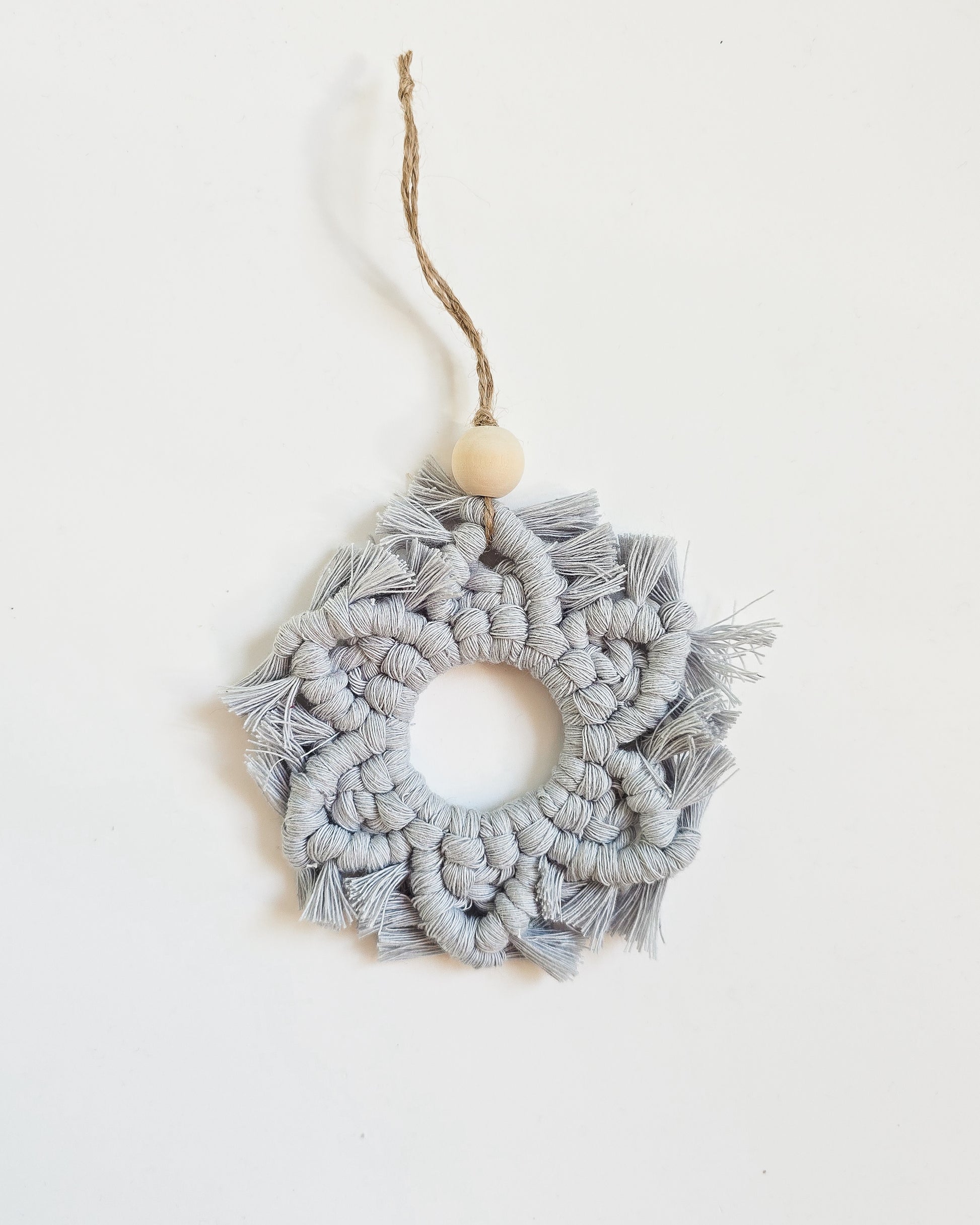 A ice blue color macrame snowflake ornaments on a white background