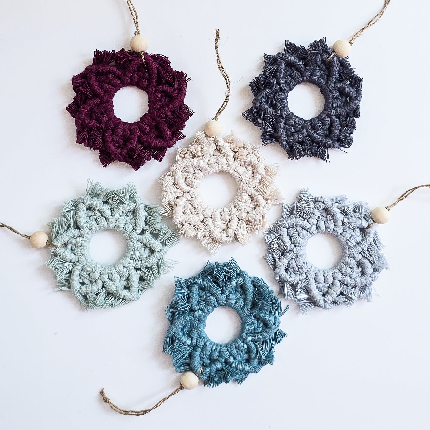 Set of colorful macrame snowflake ornaments on a white background