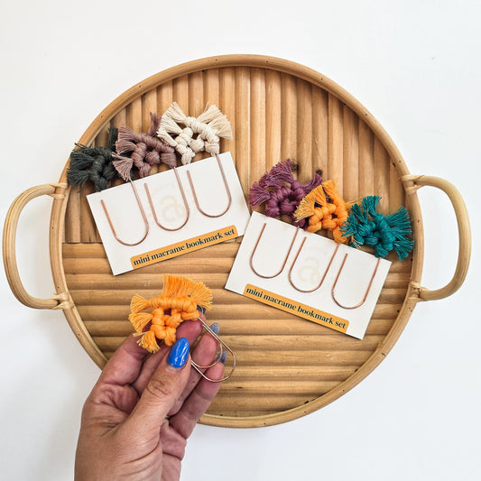 Mini macrame bookmark set with colorful bookmarks on a wooden tray.