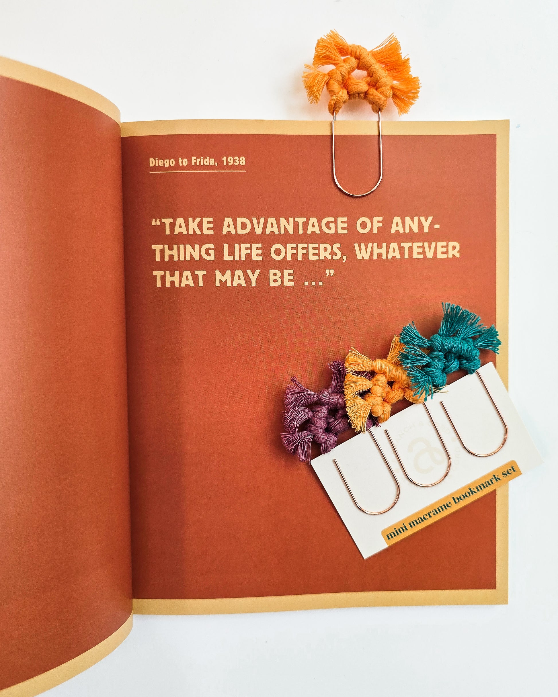 Open book with decorative bookmarks and a quote on a white background