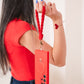 Person holding a red phone case with a lanyard against a plain background
