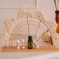 Decorative arch with small bottles on a shelf against a neutral background
