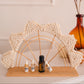 Decorative arch with macrame design holding essential oil bottles on a neutral background